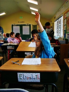 A student raises her hand for help in math class at Living Wisdom School in Palo Alto.